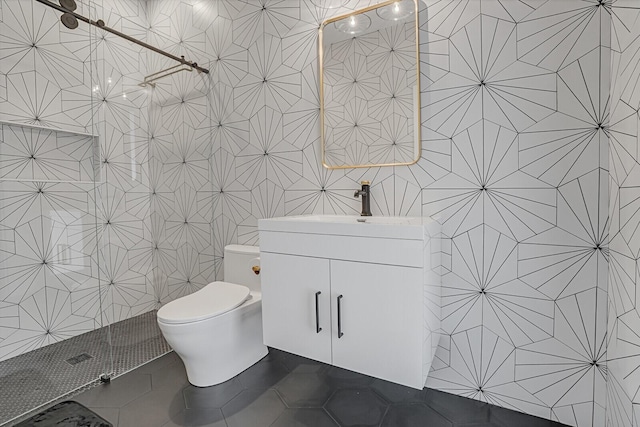 bathroom with a shower, tile walls, tile patterned flooring, vanity, and toilet