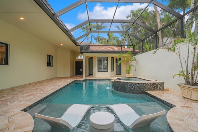 view of pool with a patio, glass enclosure, and an in ground hot tub