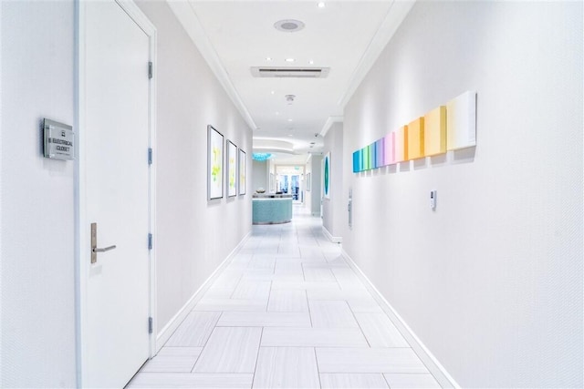 hallway with light tile patterned flooring and ornamental molding