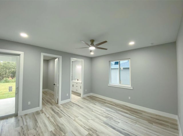 unfurnished bedroom featuring multiple windows, access to outside, ceiling fan, and ensuite bath