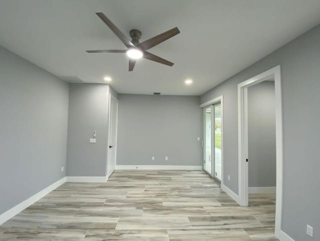 spare room with ceiling fan and light wood-type flooring