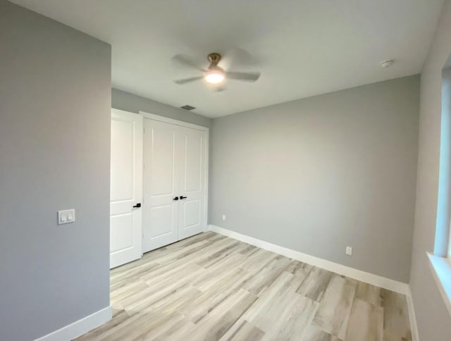 unfurnished bedroom with ceiling fan, light hardwood / wood-style floors, and a closet