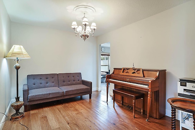 sitting room featuring a chandelier, baseboards, and hardwood / wood-style flooring