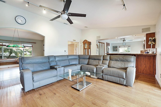 living area featuring light wood finished floors, visible vents, ceiling fan, rail lighting, and vaulted ceiling