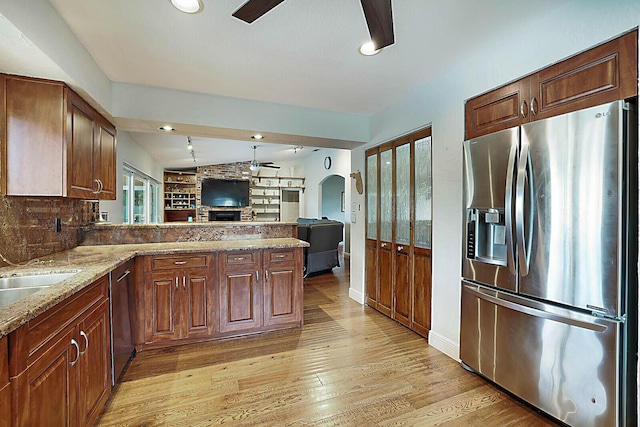 kitchen with ceiling fan, lofted ceiling, open floor plan, appliances with stainless steel finishes, and light wood finished floors