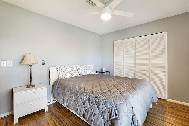 bedroom featuring baseboards, a closet, visible vents, and wood finished floors