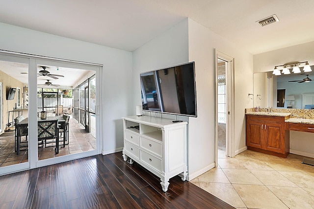 living room with baseboards, light wood-style flooring, visible vents, and a ceiling fan