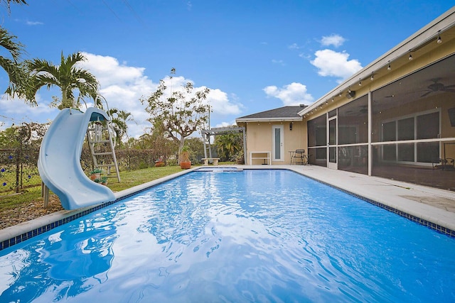 outdoor pool featuring a sunroom, a pergola, a water slide, and a patio