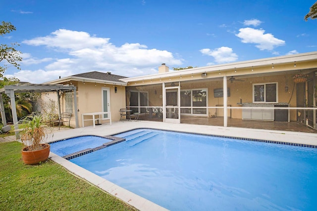 view of swimming pool with a patio, a pool with connected hot tub, a sunroom, and a pergola