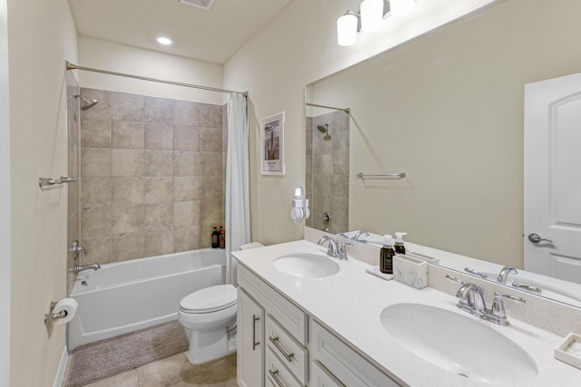 full bathroom with tile patterned flooring, shower / bath combo with shower curtain, vanity, and toilet