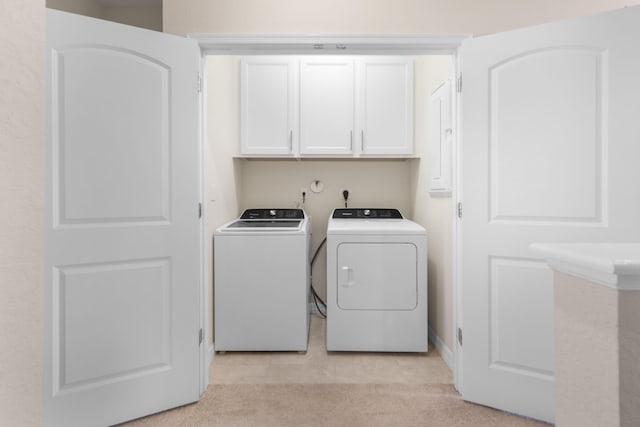 washroom with cabinets, light colored carpet, and washing machine and clothes dryer