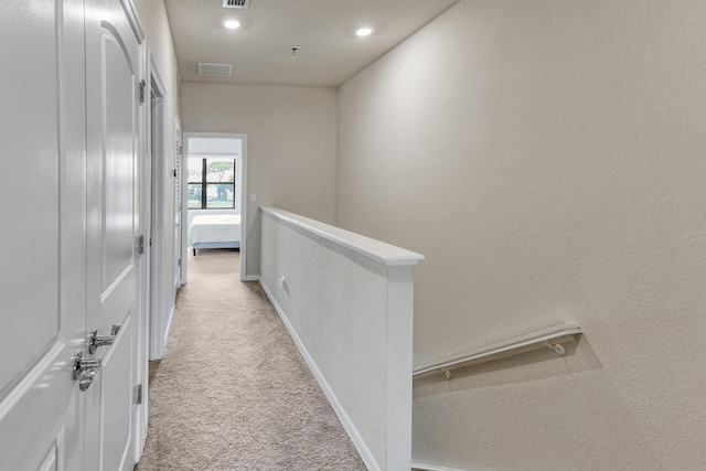 hall featuring light colored carpet