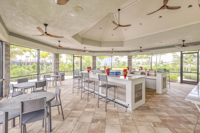 sunroom featuring a raised ceiling and wooden ceiling