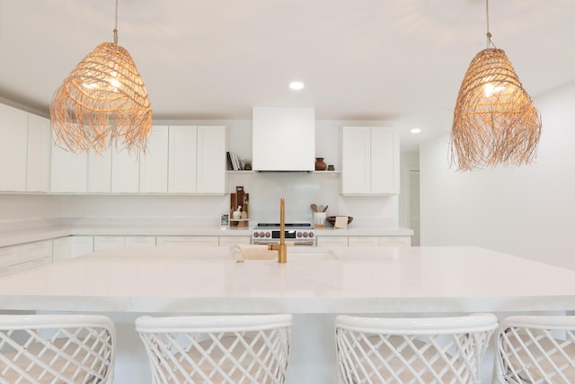 kitchen with a breakfast bar area, white cabinets, and pendant lighting