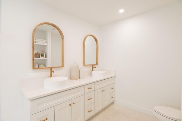 bathroom with tile patterned flooring, vanity, and toilet