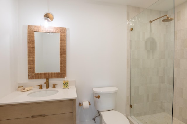 bathroom featuring vanity, toilet, and tiled shower