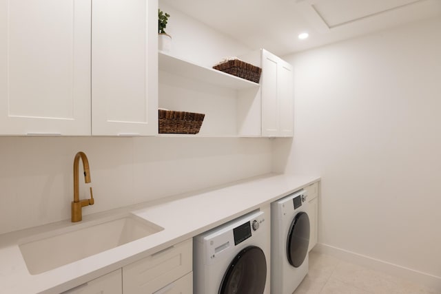 washroom with cabinets, light tile patterned floors, separate washer and dryer, and sink