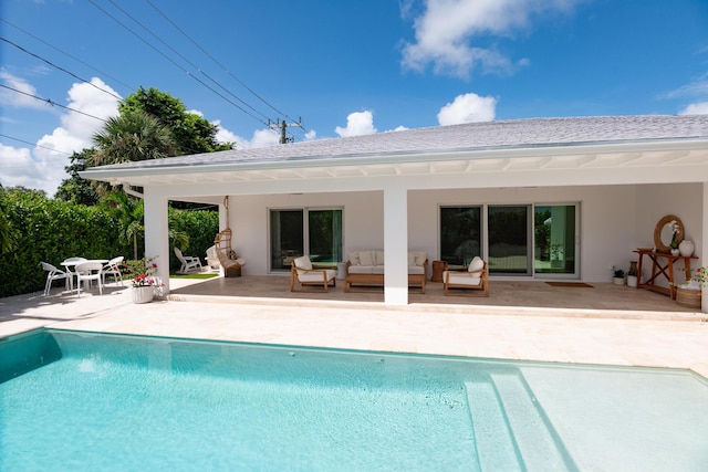 back of property with outdoor lounge area and a patio