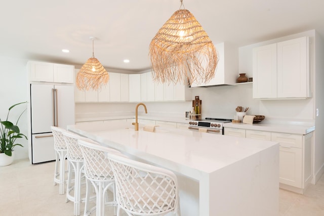 kitchen with high end fridge, white cabinetry, sink, and stainless steel range