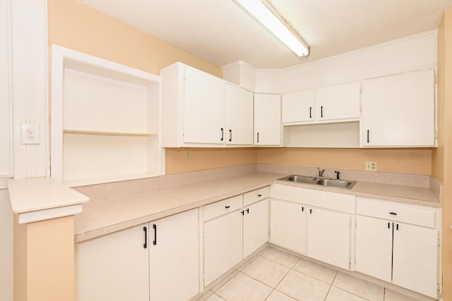 kitchen featuring white cabinets, light tile patterned floors, and sink