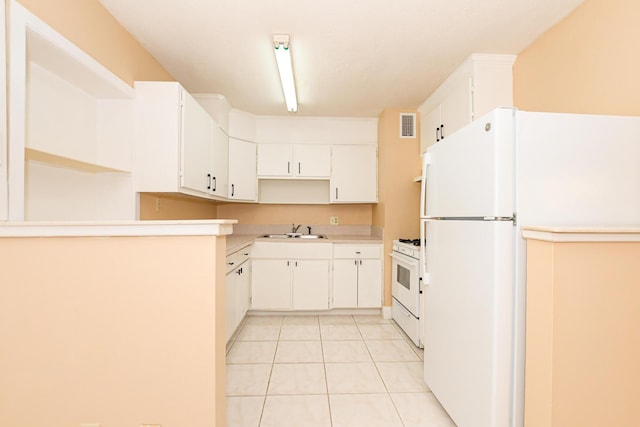 kitchen with white cabinets, light tile patterned flooring, white appliances, and sink