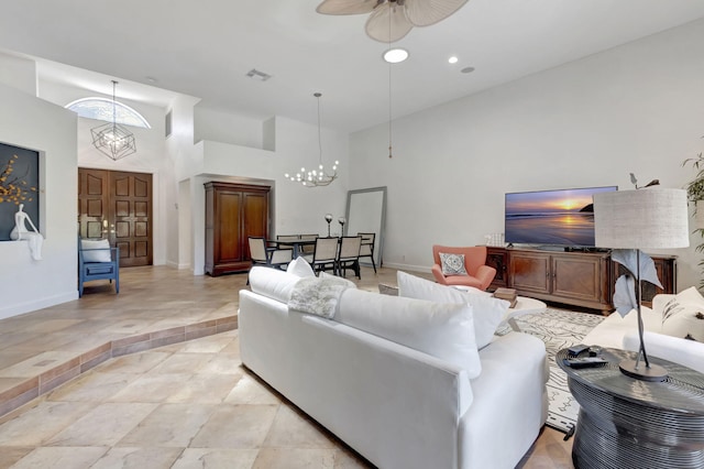 living room featuring a towering ceiling and ceiling fan with notable chandelier