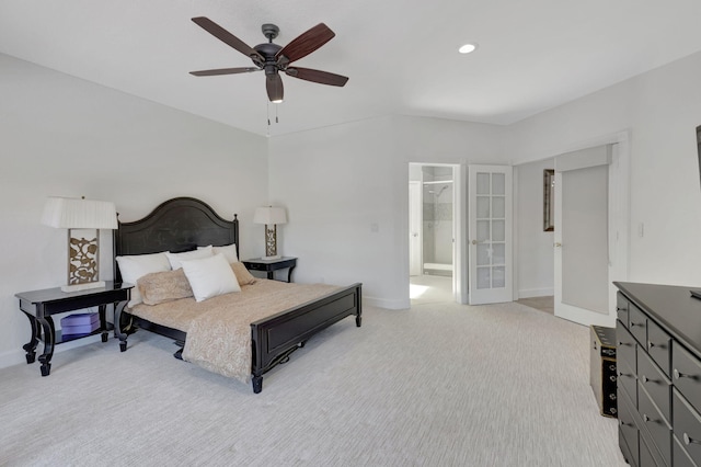 bedroom with ceiling fan, light colored carpet, connected bathroom, and french doors