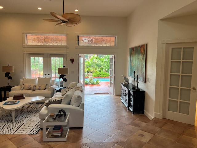 living room featuring french doors, ceiling fan, and a high ceiling