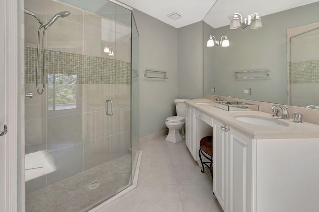 bathroom with tile patterned floors, vanity, an enclosed shower, and toilet