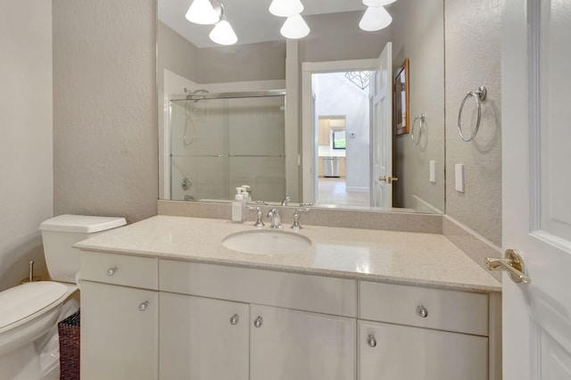 bathroom with vanity, toilet, and a shower with shower door