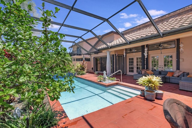 view of swimming pool featuring glass enclosure, ceiling fan, french doors, an outdoor living space, and a patio area