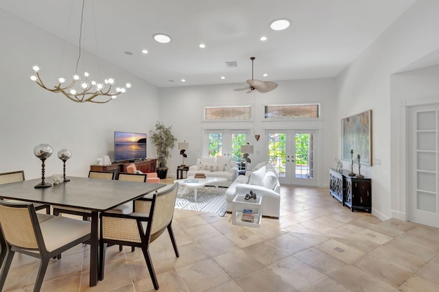 dining room featuring ceiling fan with notable chandelier, a high ceiling, and french doors