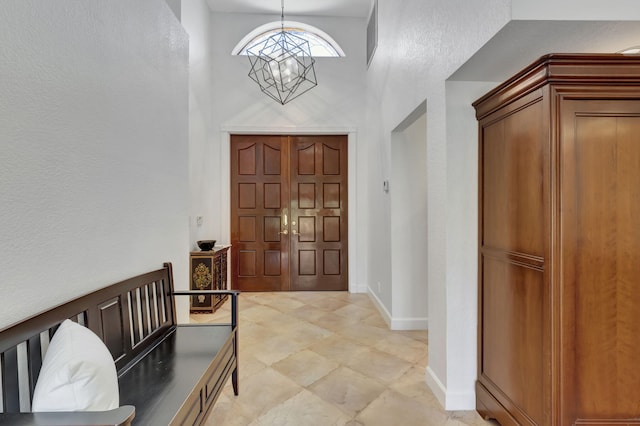 foyer entrance with a towering ceiling and an inviting chandelier