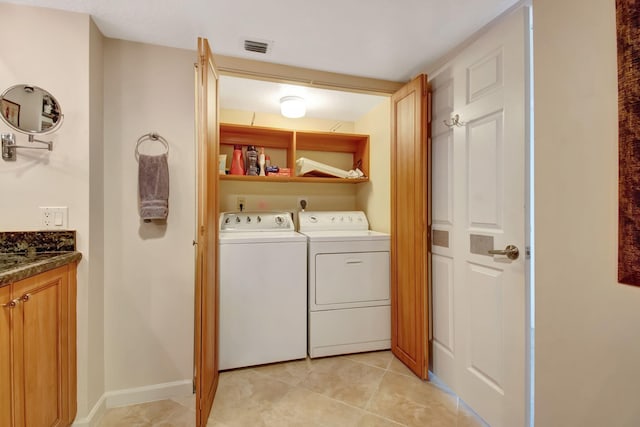 laundry area with light tile patterned floors and washing machine and clothes dryer