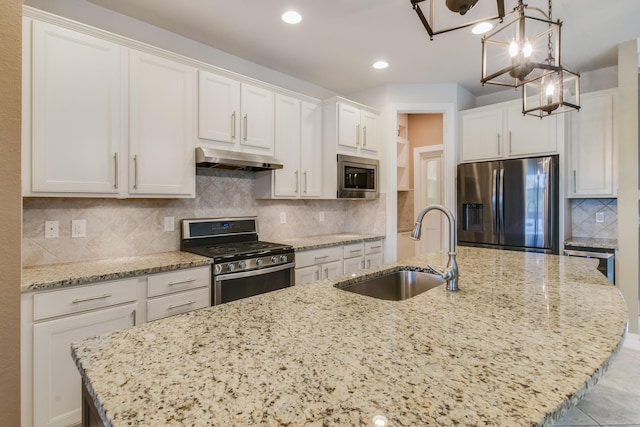 kitchen with pendant lighting, sink, an island with sink, white cabinetry, and stainless steel appliances