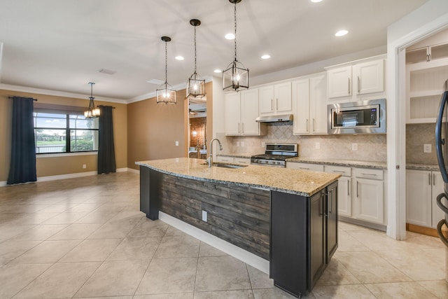 kitchen featuring stainless steel appliances, a kitchen island with sink, sink, pendant lighting, and white cabinets