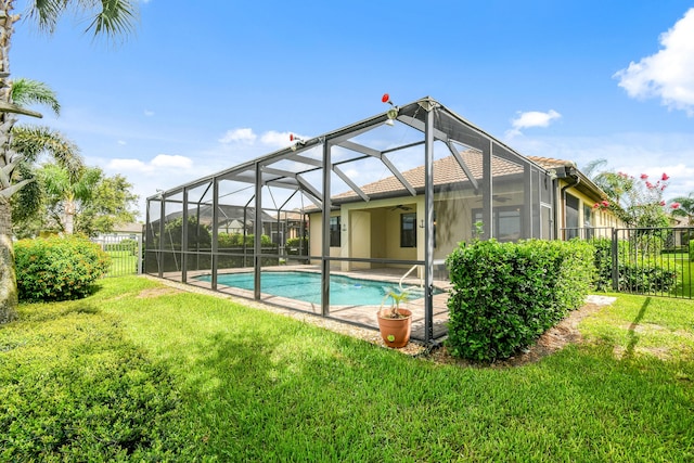 view of pool with a yard, ceiling fan, and a lanai