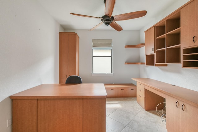 unfurnished office featuring built in desk and ceiling fan