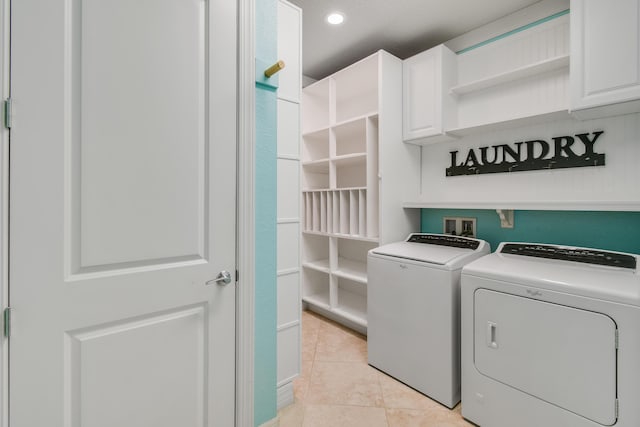 washroom featuring cabinets, light tile patterned floors, and washing machine and dryer