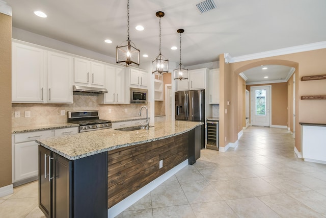 kitchen featuring a kitchen island with sink, sink, wine cooler, white cabinetry, and stainless steel appliances