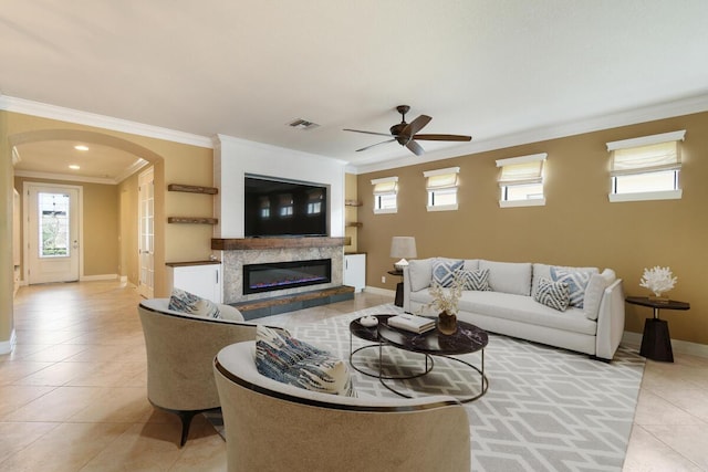 living room featuring ceiling fan, ornamental molding, and light tile patterned flooring