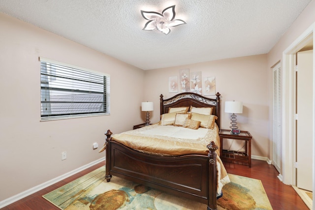 bedroom with a textured ceiling, a closet, and dark wood-type flooring