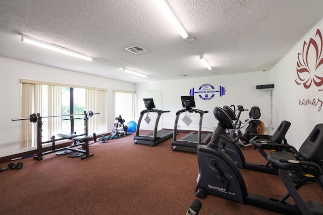 gym featuring carpet and a textured ceiling