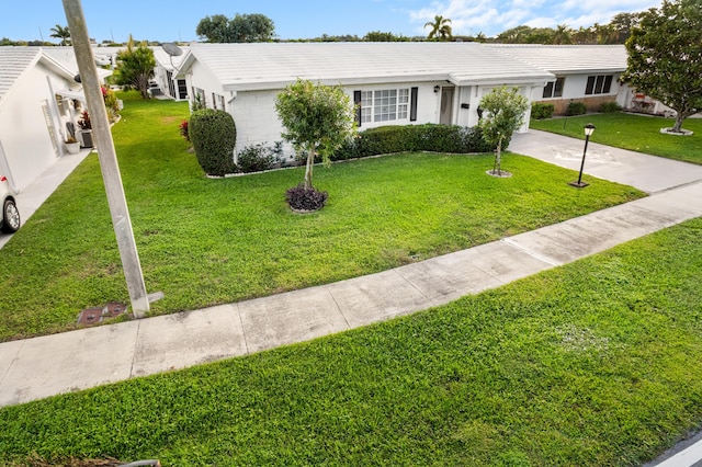 single story home featuring a garage and a front yard