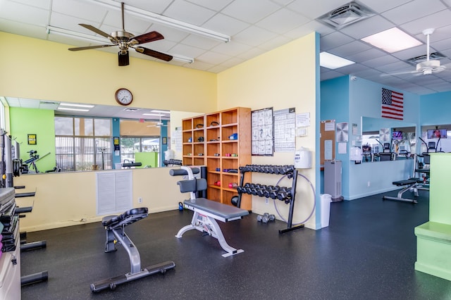 exercise room featuring ceiling fan and a drop ceiling