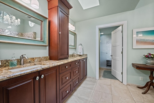 bathroom with vanity, tile patterned floors, and a skylight