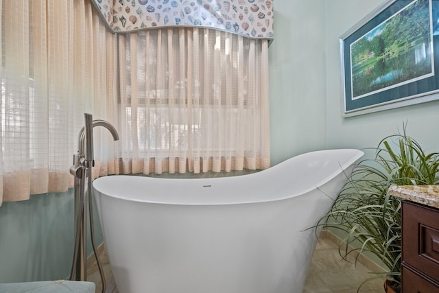 bathroom with a bath, tile patterned flooring, and vanity