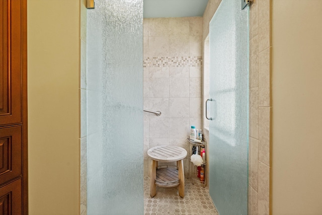 bathroom with tile walls and a shower with shower door