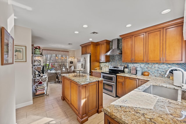 kitchen featuring light stone countertops, wall chimney exhaust hood, stainless steel appliances, backsplash, and sink