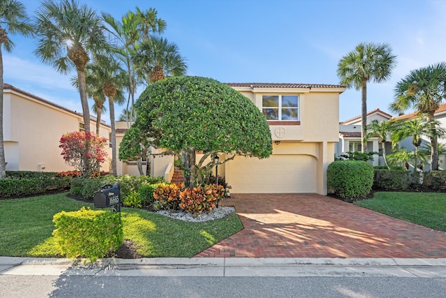 mediterranean / spanish-style home featuring a front lawn and a garage